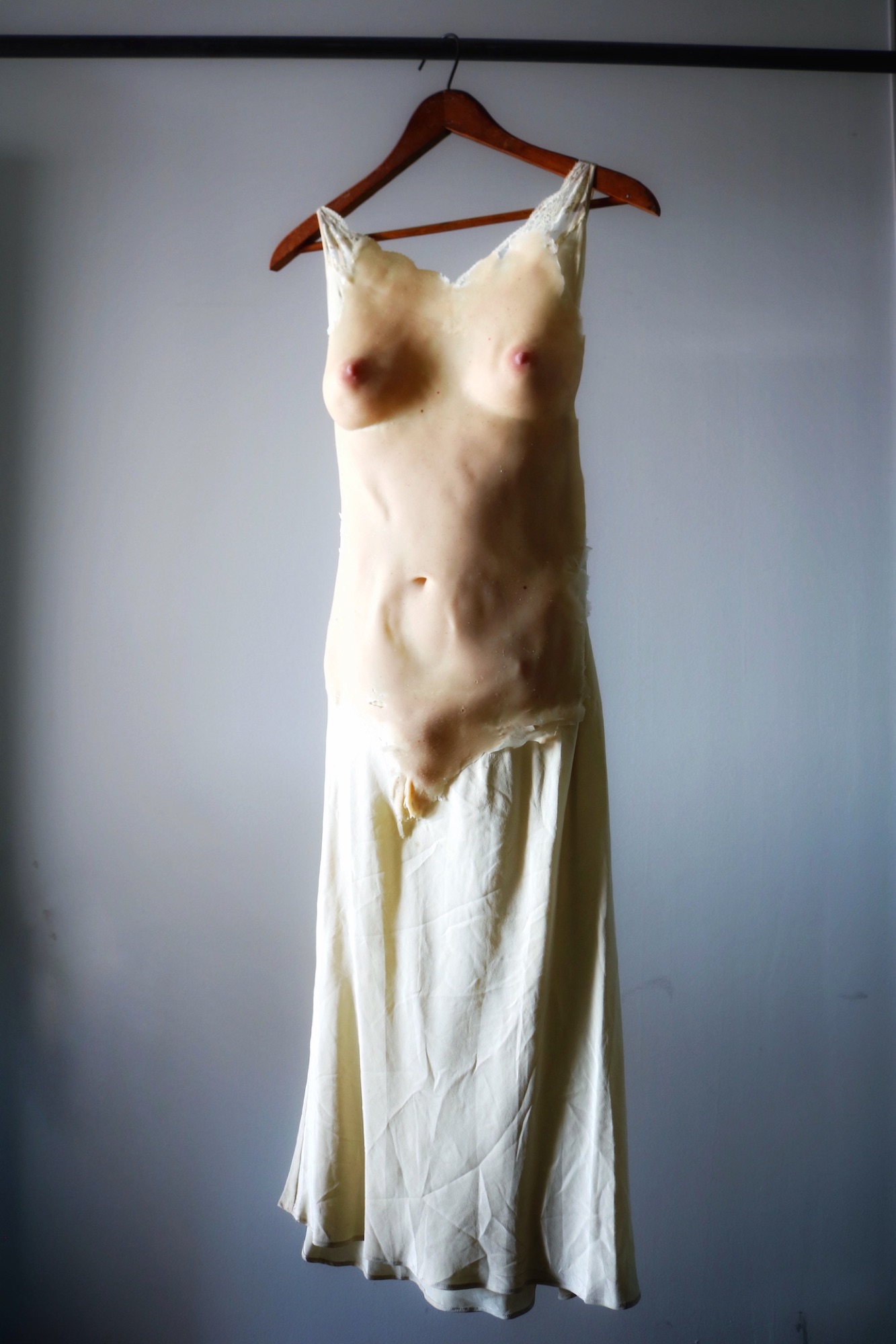The nightgown hanging against a grey-blue backdrop