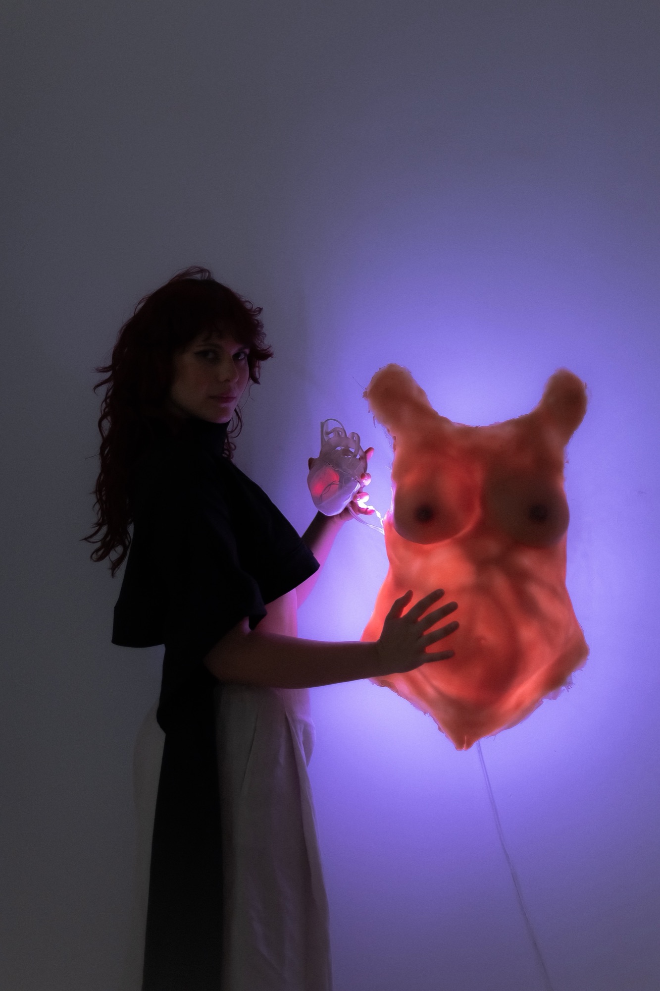 SOURCE: Manuela touches the silicone torso on the wall and it glows violet from within